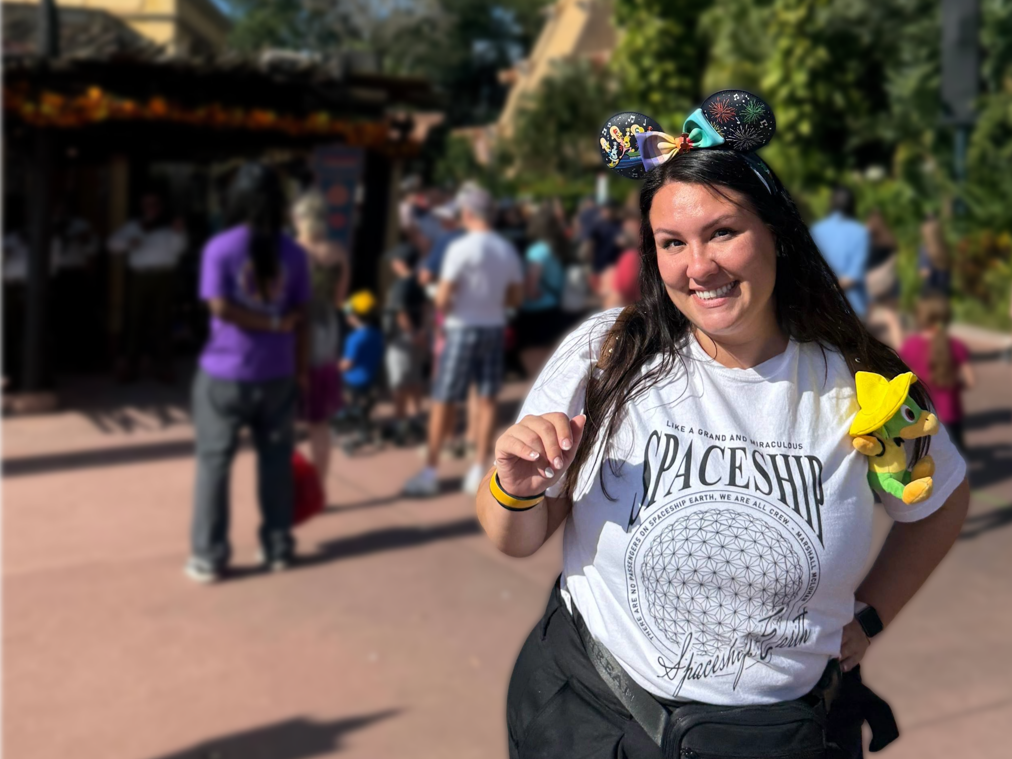 Woman wearing a 'Spaceship Earth' t-shirt and Mickey ears at a theme park.
